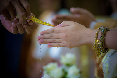 Midsection of bride with hands clasped during religious ritual