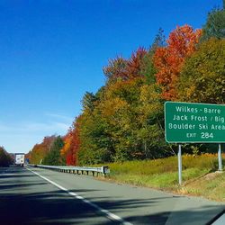 Close-up of road sign against clear blue sky