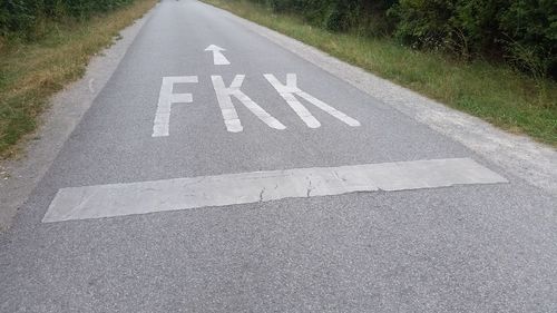 High angle view of alphabets with arrow symbol on road