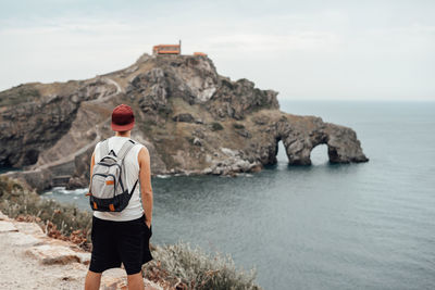 Rear view of man looking at sea against sky