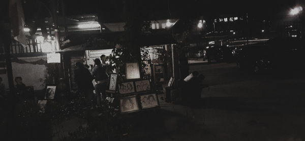 People at illuminated street in city at night