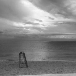 Goal post at sandy beach against sky