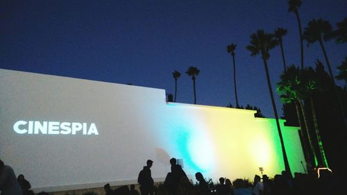 People at music concert against clear blue sky