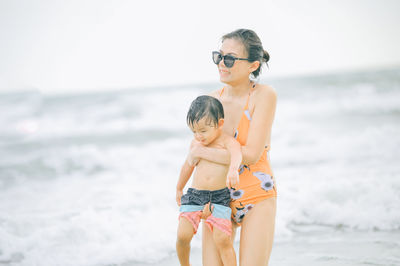 Mother and daughter standing on beach