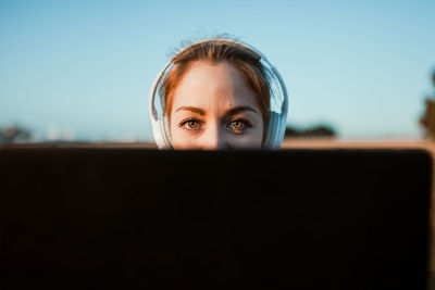 Close-up portrait of woman wearing sunglasses against sky