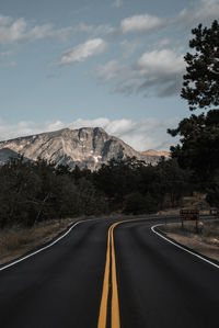 View of country road against cloudy sky