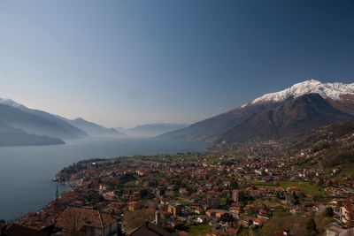 High angle view of houses by river amidst mountains against sky