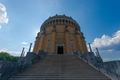 Low angle view of staircase amidst building against sky