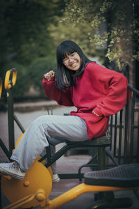 Portrait of young woman sitting on seat