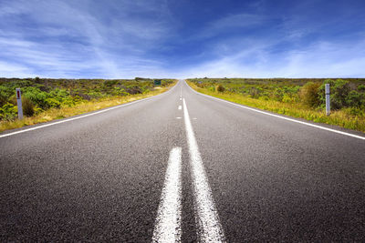 Road passing through land against sky