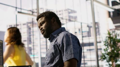 Side view of young man standing in city