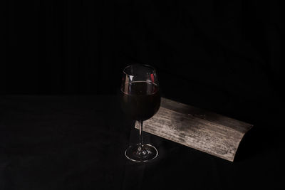 Wineglass on table against black background