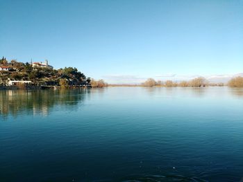 Scenic view of lake against clear blue sky