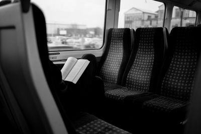 Midsection of woman reading book while traveling in train