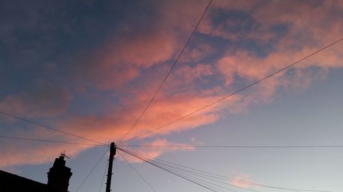 Low angle view of birds flying over cloudy sky