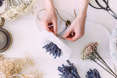 Hands of a florist woman at work. dry compositions of flowers and plants for the interior