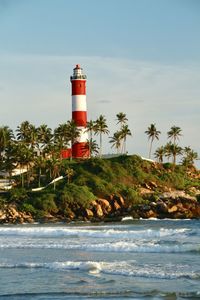 Lighthouse by sea against sky