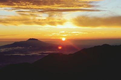 Scenic view of mountains against sky at sunset