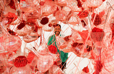 Bottles and containers in net with smiling man standing in background