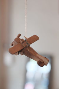 Close-up of wooden toy airplane hanging on wall