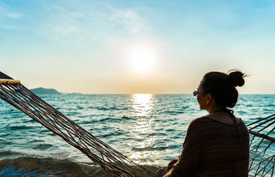 Woman looking at sea against sky