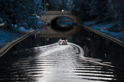 People on bridge over river