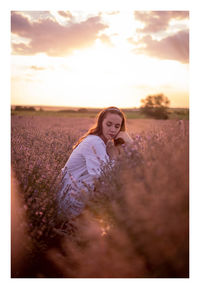 Woman standing in a lavender field during sunset 