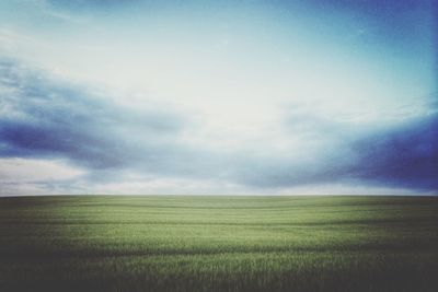 Scenic view of field against cloudy sky