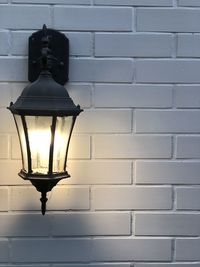Low angle view of illuminated lamp mounted on wall