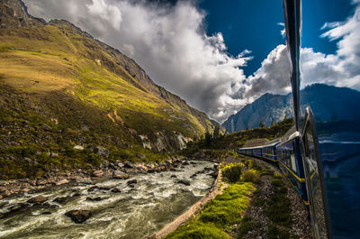 Passenger train by river in andes