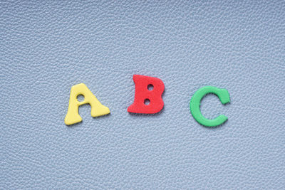 Directly above shot of colorful foam alphabets on gray table
