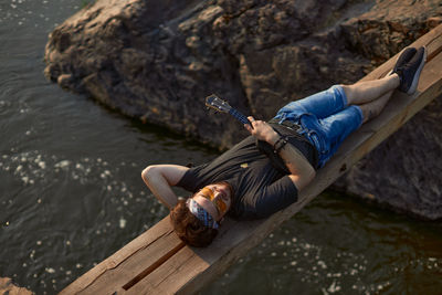 High angle view of person sitting on rock