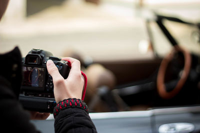 Cropped hand of woman photographing with camera