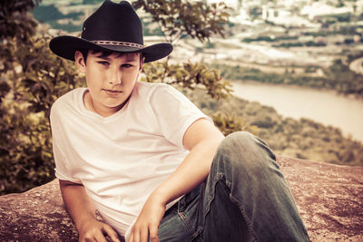 Young man sitting on rock