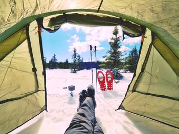 Resting in tent while winter hiking. view from inside of tent to winter mountains. legs of the tent