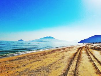 Scenic view of beach against clear blue sky