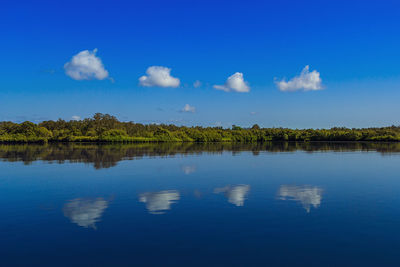 Scenic view of calm lake against blue sky