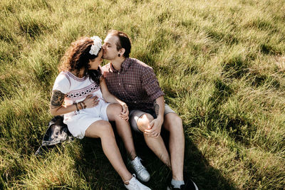 High angle view of man kissing woman on field