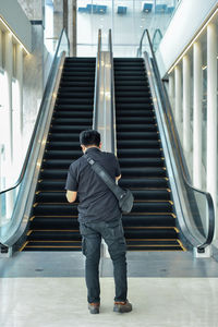 Rear view of man walking on staircase