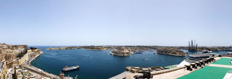 High angle view of sailboats moored at harbor against clear sky