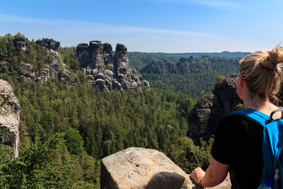 Rear view of person on rocks against mountains