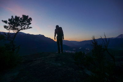 Silhouette man standing on mountain against clear sky