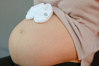 Close-up of pregnant woman with baby booties