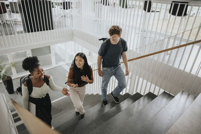 High angle view of happy multiracial students moving up on steps in university