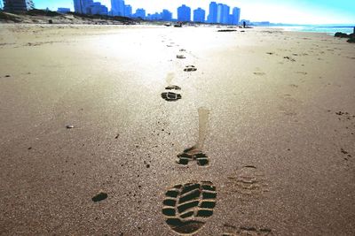 Close-up of footprints on sand at beach