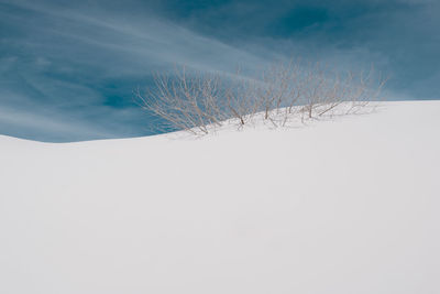 Snow covered land against sky