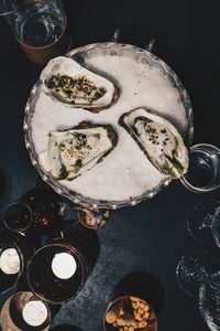 Overhead view of three oysters on a bed of sea salt