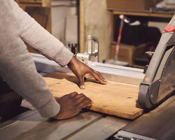 Midsection of carpenter working at workshop