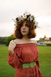 Portrait of beautiful woman standing by flower