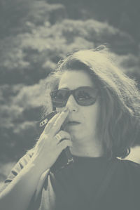 Portrait of woman holding sunglasses